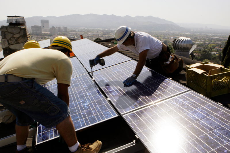 Workers install solar photovoltaic panels on the roof of a home in Glendale, California in March, 2010. Image: AP Photo/Reed Saxon, File